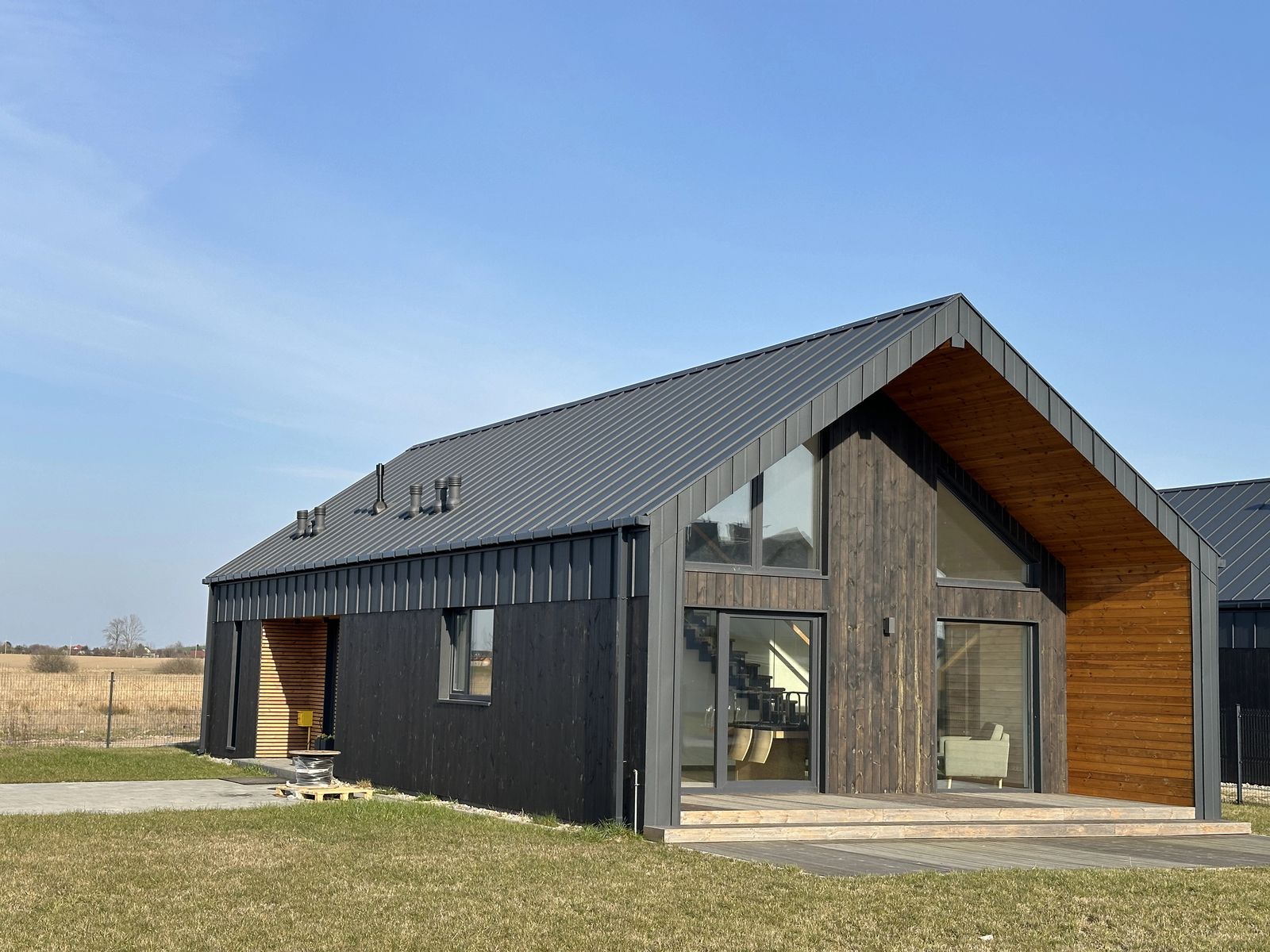Zwart gebeitste houten woning met glazen gevel